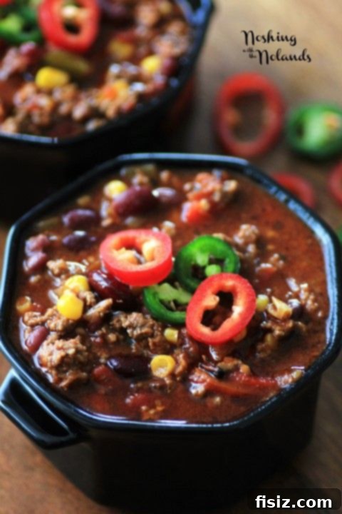 10 Ultimate Tailgate Chili Recipes 10 A close-up of a rich, hearty bowl of 'Best Damn Chili' with cheese and sour cream.