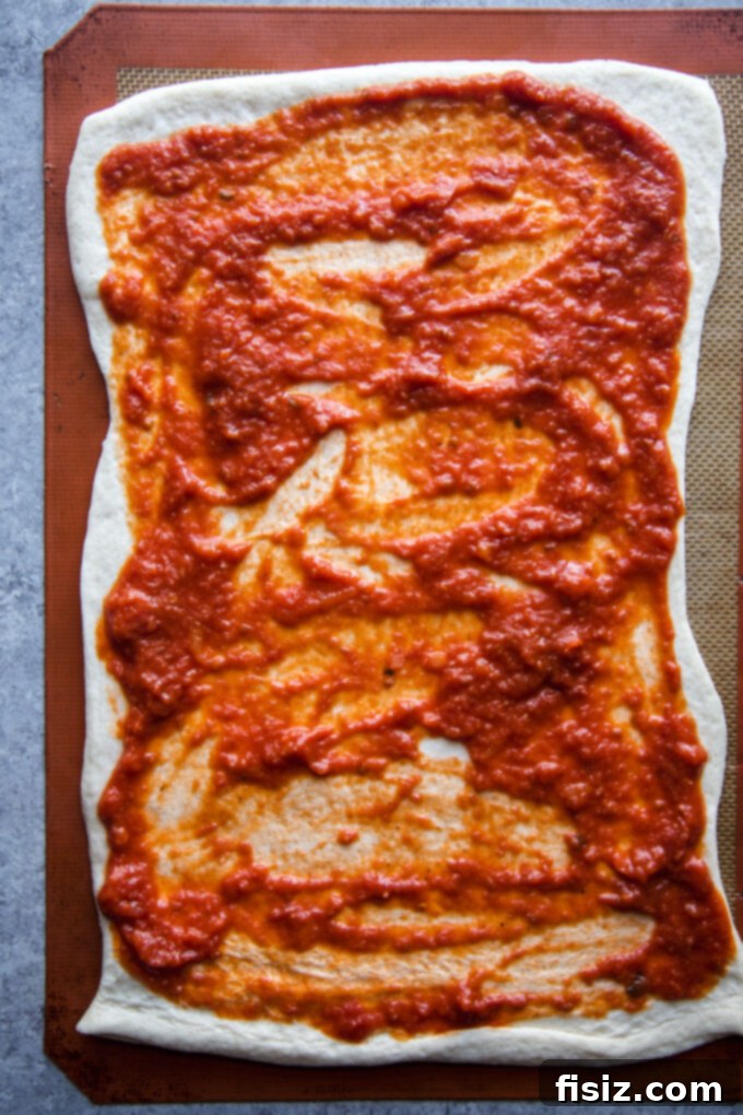 Pizza dough covered in sauce